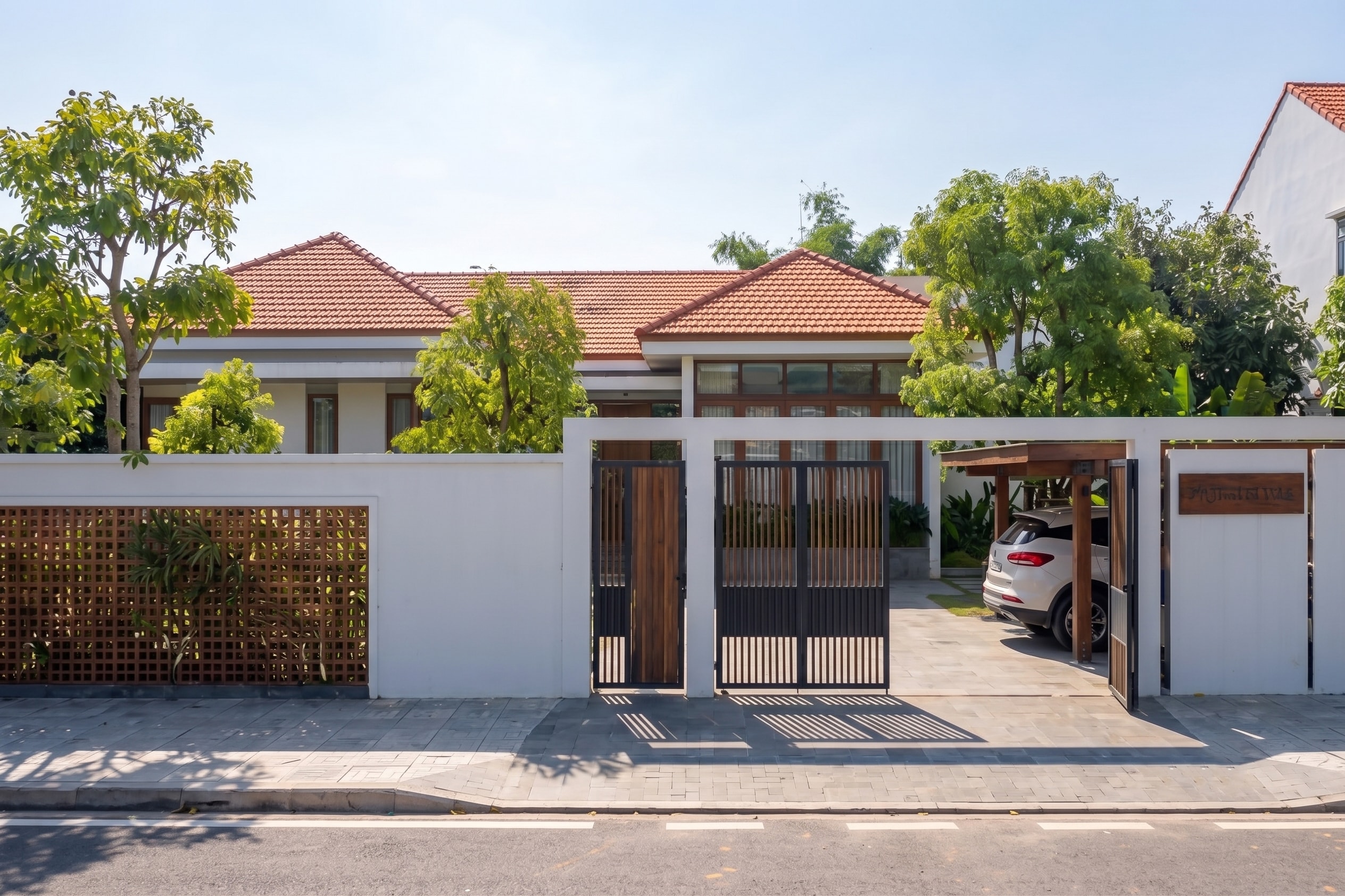 Cổng và sân đậu xe của AJ House nhìn từ ngoài đường